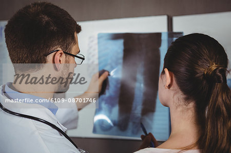Physiotherapist explaining spine x-ray to female patient in the clinic