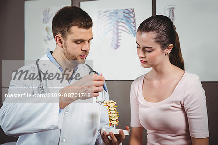 Physiotherapist explaining the spine to female patient in the clinic