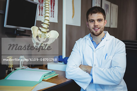 Portrait of physiotherapist sitting at his desk in the clinic