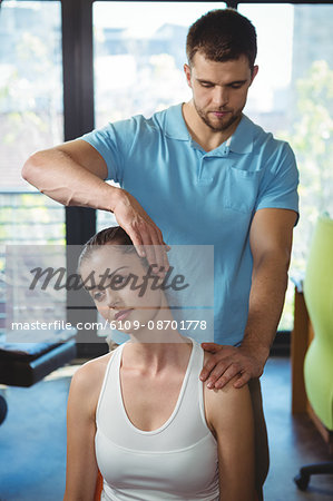 Physiotherapist stretching neck of a female patient in the clinic