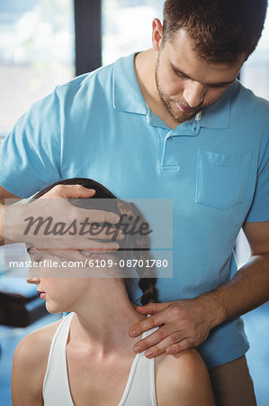 Physiotherapist stretching neck of a female patient in the clinic