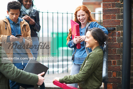 Young male and female college students chatting on campus