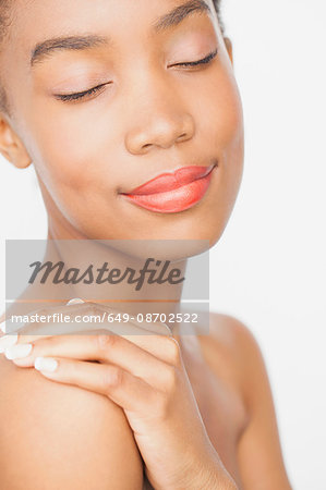 Woman wearing lipstick, hand on shoulder, eyes closed