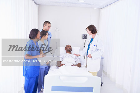 Doctors and nurses surrounding patient in hospital bed