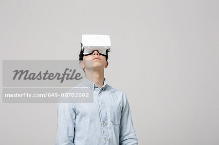 Young man wearing virtual reality headset looking up