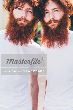 Portrait of young male hipster twins with red beards wearing white tshirts Portrait of young male hipster twins with red beards wearing white tshirts