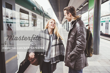 Young couple departing on train station platform