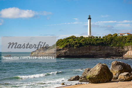 Rocks on the sandy beach and the lighthouse in Biarritz, Pyrenees Atlantiques, Aquitaine, France, Europe
