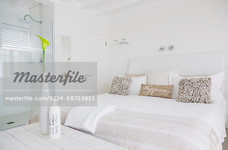 White bedroom with en suite shower in luxury hotel room