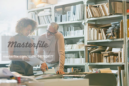 Businessman and businesswoman discussing paperwork in office