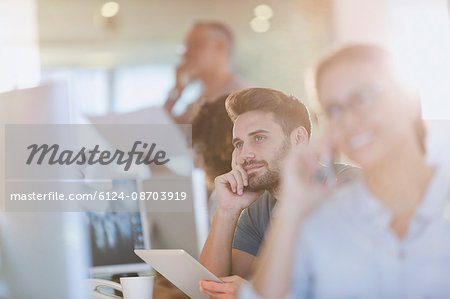 Pensive businessman using digital tablet in office