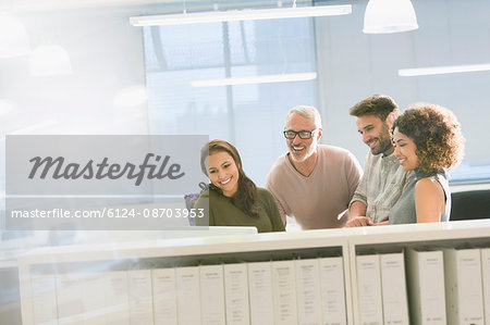 Smiling business people working at computer in office