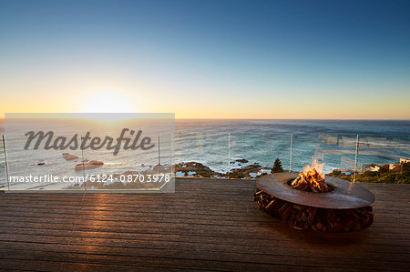 Fire pit on luxury patio with sunset ocean view