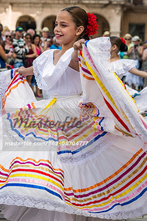 Cuba, Havana, Plaza de Armas, Habana Vieja. A young girl participates in a public dancing display at Plaza de Armas, Havanas oldest square which was laid out in the 1520s. Cuba, Havana, Plaza de Armas, Habana Vieja. A young girl participates in a public dancing display at Plaza de Armas, Havanas oldest square which was laid out in the 1520s.