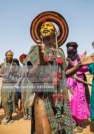 Niger, Agadez, Inebeizguine. Young Wodaabe men in traditional embroidered garments perform the rumi dance during a Gerewol ceremony.