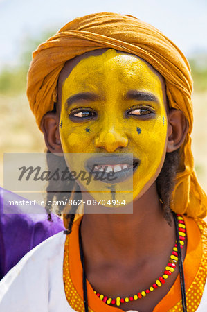 Niger, Agadez, Inebeizguine. A young Wodaabe man with a painted face during a Gerewol ceremony.