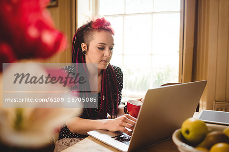 Young woman using laptop while sitting at home