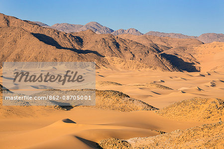 Niger, Agadez, Sahara Desert, Tenere, Kogo. Sand dunes on the edge of the vast Tenere Desert with the Taghmert Mountains in the distance.