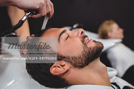 Smiling man getting his hair wash at a salon