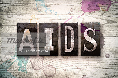 The word "AIDS" written in vintage dirty metal letterpress type on a whitewashed wooden background with ink and paint stains.