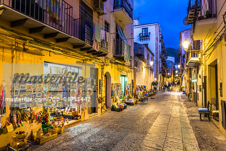 Shops along Narrow Street at Night in Cefalu, Sicily, Italy Shops along Narrow Street at Night in Cefalu, Sicily, Italy