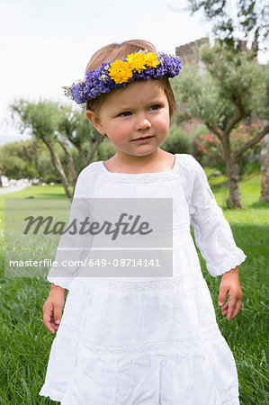 Portrait of female toddler in garden wearing floral headdress, Beja, Portugal