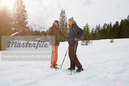 Couple snowshoeing across snowy landscape, Elmau, Bavaria, Germany
