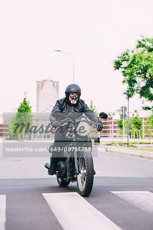 Male motorcyclist motorcycling on pedestrian crossing