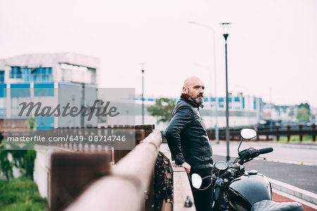 Mature male motorcyclist watching from roadside