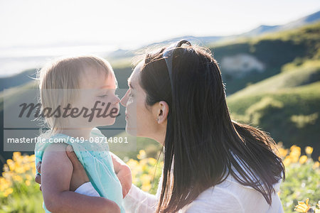 Mother holding young daughter, touching noses, hiking the Bonneville Shoreline Trail in the Wasatch Foothills above Salt Lake City, Utah, USA