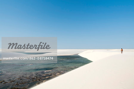 Brazil, Maranhao, Atins, Lencois Maranhenses national park, a man walking over the dunes in the Rio Negro district of the park