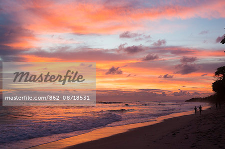 Playa Santa Teresa at sunset, Mal Pais, Costa Rica. Young girl looking at the ocean on the beach.