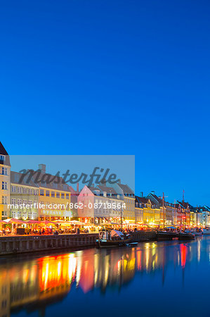 Denmark, Hillerod, Copenhagen. Colourful buildings along the 17th century waterfront of Nyhavn at dusk.