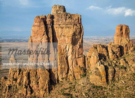 Ethiopia, Tigray Region, Gheralta Mountains, Guh. The priest at the important ancient rock-hewn of Abune Yemata can be seen at the entrance to his church half way up the stunning Guh feature in the Gheralta Mountains.