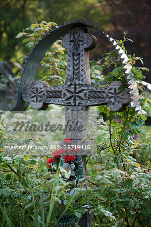 Romania, Maramures, Breb. A carved wooden cross marking a grave in the cemetery.