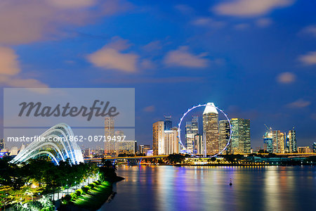 South East Asia, Singapore, Gardens by the Bay cloud forest and city backdrop of Marina Bay, Singapore Flyer ferris wheel