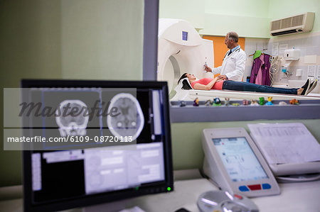 Digital brain scan on computer monitor with mri scanner in background