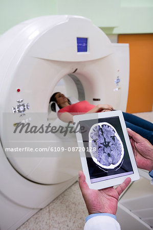 Doctor looking at brain mri scan on digital tablet at hospital