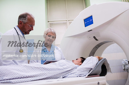 Doctors interacting with patient in scanning room at hospital