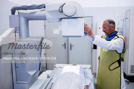 Doctor using x-ray machine to examine patient in hospital