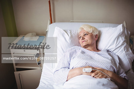 Thoughtful senior woman on a bed in hospital