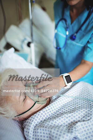 Nurse putting oxygen mask on patient in hospital