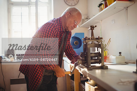 Goldsmith manufacturing ring in workshop