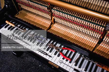 Close-up of repairing tools kept on old piano keyboard