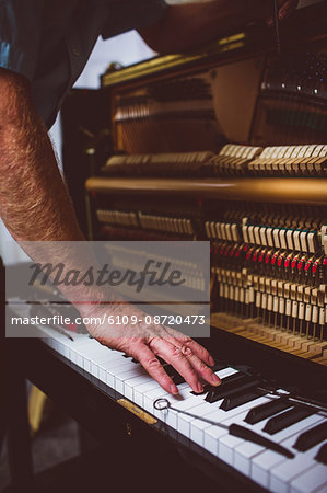 Piano technician repairing the piano at workshop