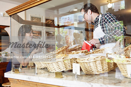 Customer in bakery pointing to baked goods