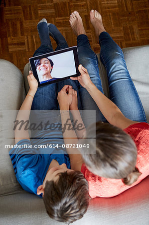 Overhead view of mother and son on sofa using digital tablet