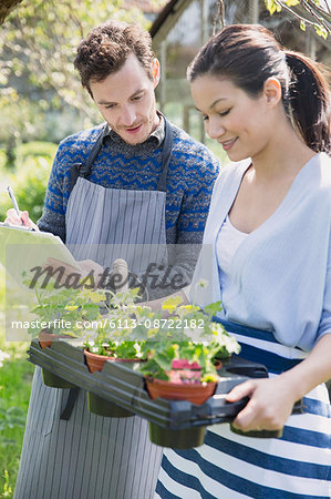 Plant nursery workers with clipboard and potted plants