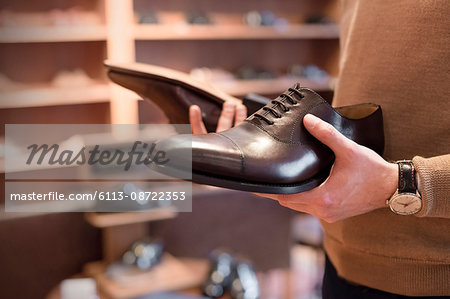 Businessman browsing dress shoes in menswear shop