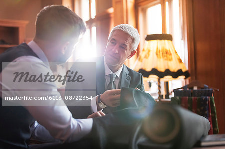 Tailor and businessman discussing suit in menswear shop Tailor and businessman discussing suit in menswear shop